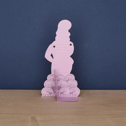 The back of a standing pink die-cut card shaped like a dancer, featuring dotted lines on her torso for writing a message and a fold-out base stand.
