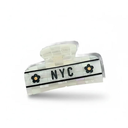 Hair clip with 'NYC' and floral designs on a white background