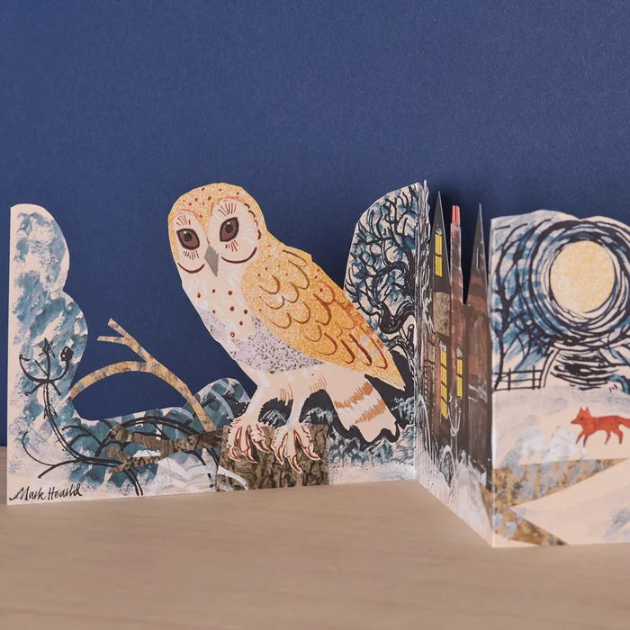 An angled close-up view of the freestanding die-cut card highlighting a detailed illustration of a perched barn owl next to a full moon and bare winter trees.