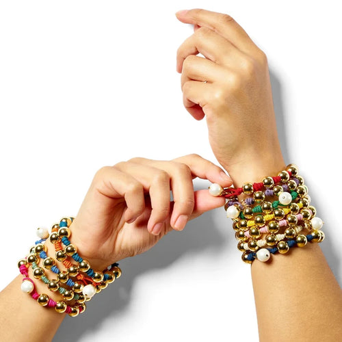 Two hands wearing colorful beaded bracelets on a white background