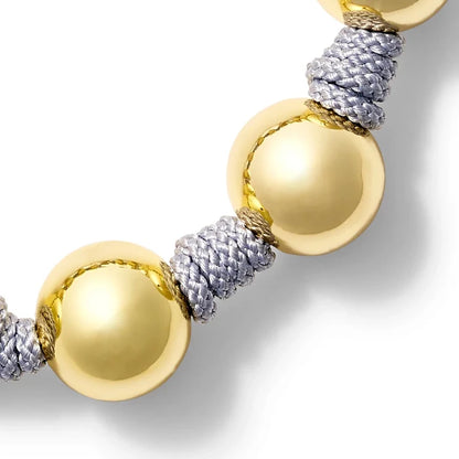 Bracelet with gold and textured silver threads on a white background