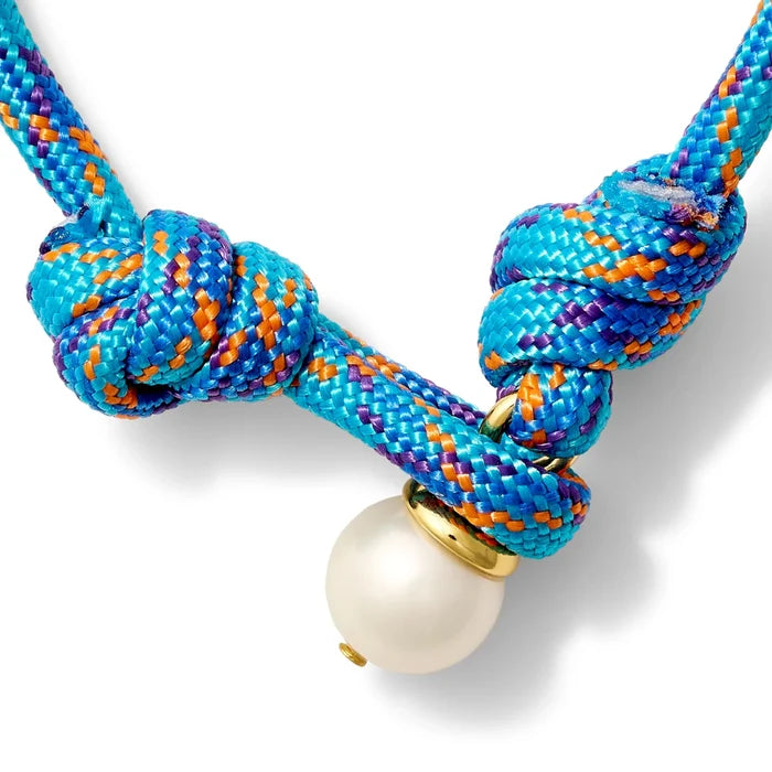 Bright blue, orange and purple bracelet with a pearl button closure on a white background